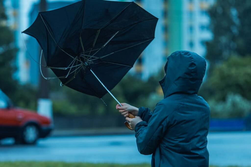 windy storm with person holding an umbrella